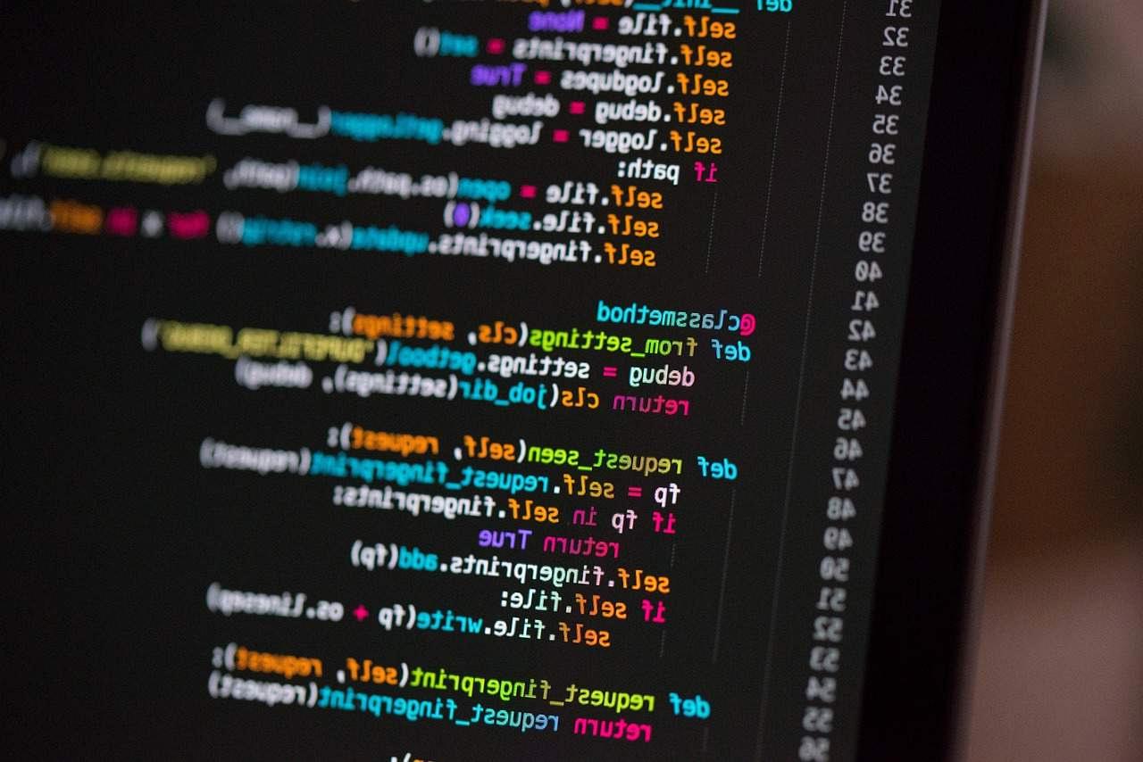 LaravelとFastAPIのロゴを背に、設計図を広げて考えるエンジニアのシルエット