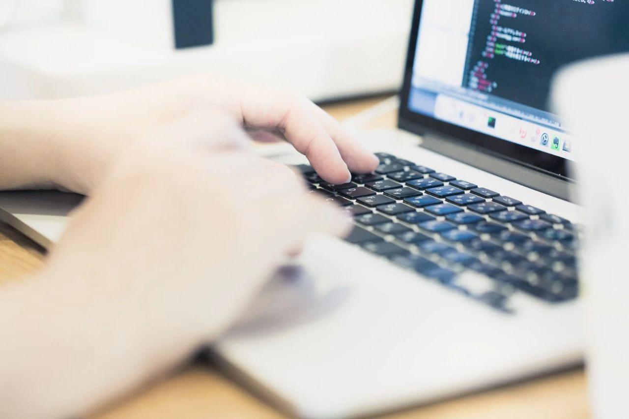 LispとCOBOLのコードが並び、現代のWebアーキテクチャの図式が背景にある比較画像