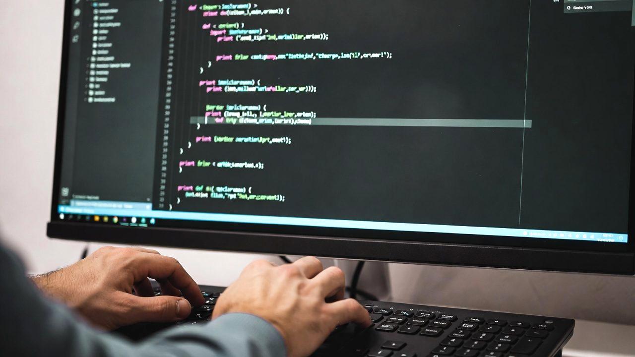 データ転送の遅延を示す砂時計とパソコンの画像